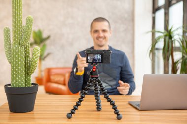 Tripod 'daki kamera ve video blogu için kendini çeken adam.
