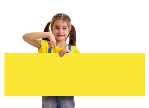 Маленькая девочка держит длинный желтый пустой баннер на белом фоне — стоковое фото
