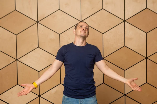 Man as a saint pose at wooden background — Stock Photo, Image