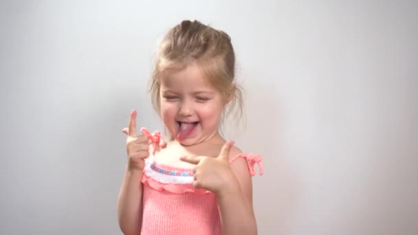 Kleines Mädchen hat Spaß und zeigt lustige Gesichter — Stockvideo