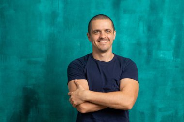 Çapraz elli yakışıklı bir adamın portresi.