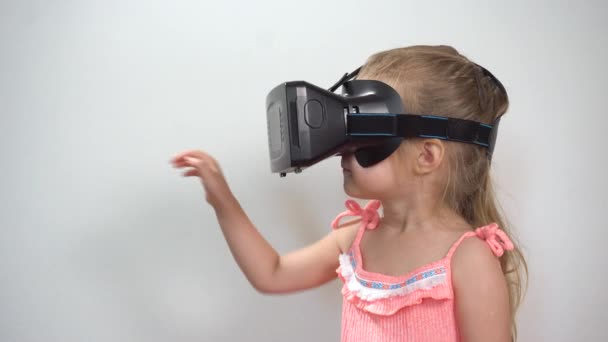 Kleines Mädchen trägt Virtual-Reality-Helm und spielt virtuelles Spiel — Stockvideo