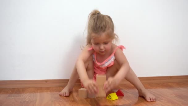 Mała dziewczynka budynek wieża z drewnianych bloków — Wideo stockowe