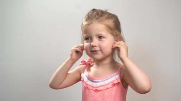 Изолированная маленькая девочка танцует и слушает музыку — стоковое видео