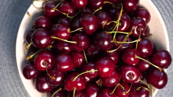 Cuenco de cerezas rojas en la mesa. Placa giratoria de cereza dulce . — Vídeo de stock