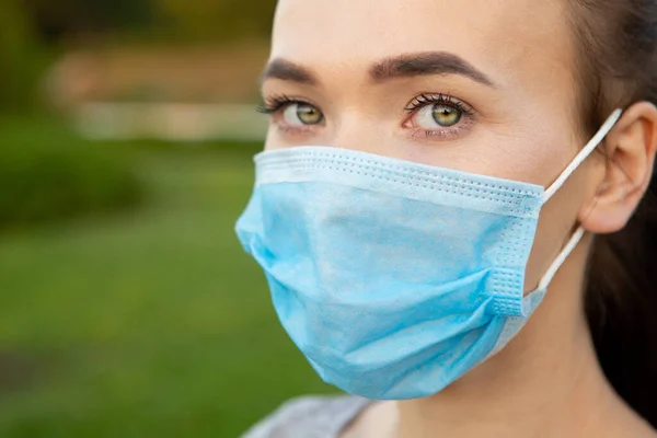 Mooie vrouwen in een medisch blauw masker — Stockfoto