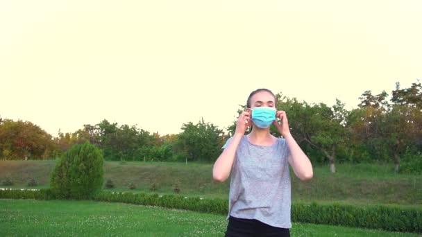 Jonge vrouw neemt medische masker af en ademt diep. — Stockvideo