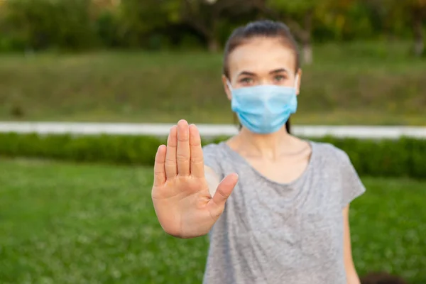 Vrouw in medisch masker show stop gebaar met de hand — Stockfoto