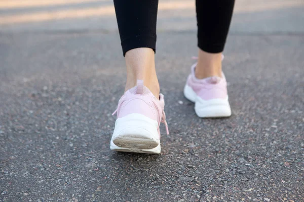 Primer plano en zapatillas de correr de mujer en el camino de correr . —  Fotos de Stock