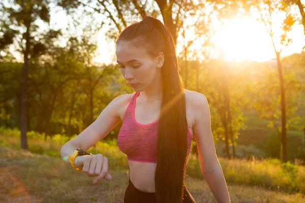 Женщина проверяет свою фитнес-часы и отслеживает состояние здоровья носимое устройство — стоковое фото