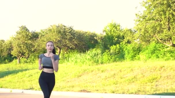도시 공원에서 뛰고 있는 젊은 여자에 대한 앞쪽의 광경 — 비디오