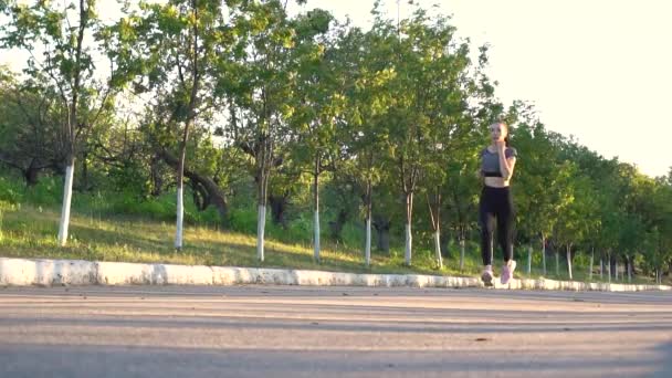 Ung sportig kvinna tränar med utomhus kör i stadsparken. — Stockvideo