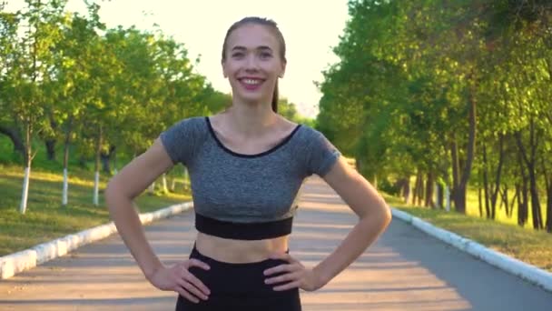 Portret van sportieve atletische vrouw in sportkleding op zoek in camera. — Stockvideo