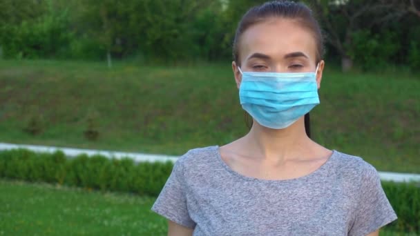 Portrait d'une jeune femme portant un masque de protection dans la rue. — Video