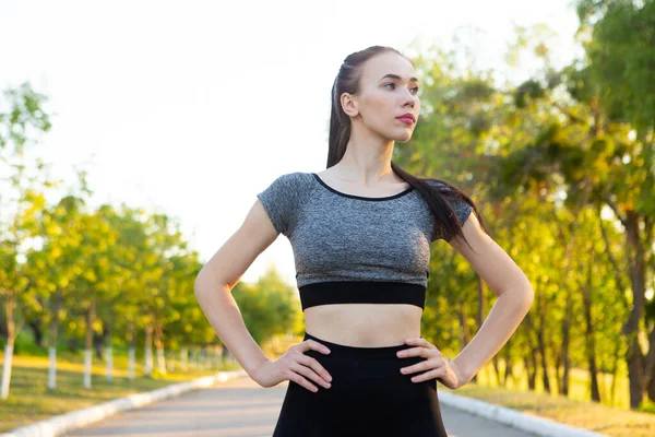 Retrato de mujer atlética deportiva en ropa deportiva en carretera en el parque . —  Fotos de Stock