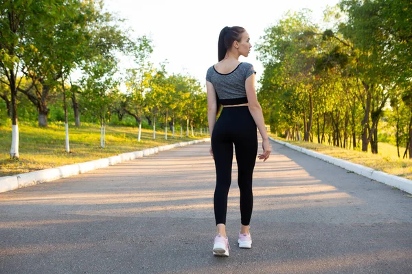 Widok z tyłu sportowca biegacz kobieta w letnim parku miejskim. — Zdjęcie stockowe