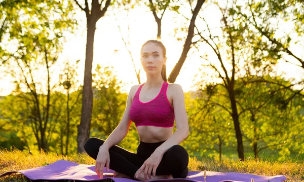 Mulher olha para o fundo de um belo nascer do sol — Fotografia de Stock