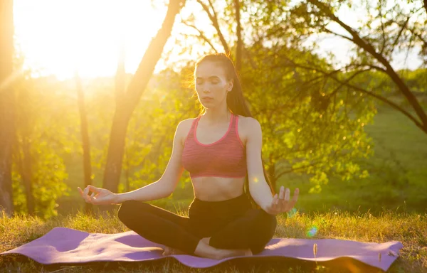 Das Mädchen praktiziert Yoga an der frischen Luft, voller Energie für den Tag. — Stockfoto