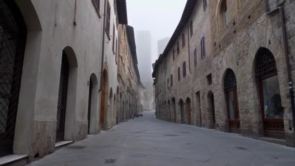 Walking down the street of San Gimignano medieval town early in the morning. Tuscany, Italy. — Stock Video