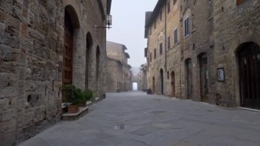 San Gimignano tarihi kent. Toskana, İtalya San Gimignano Ortaçağ şehrin cadde boyunca hareketli kamera. UHD, 4k