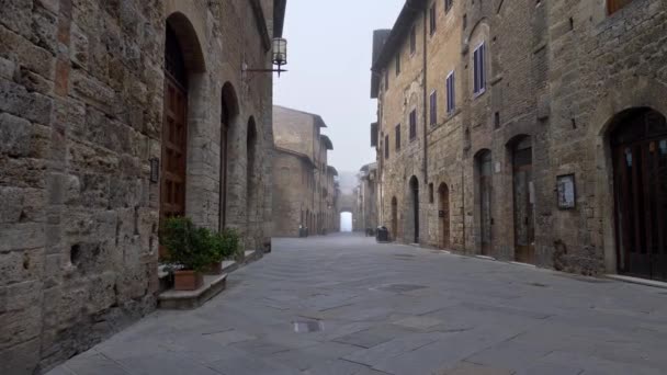 サン ・ ジミニャーノの旧市街。トスカーナ州、イタリアのサン ・ ジミニャーノの中世の町の通りに沿って移動するカメラ。4 k Uhd — ストック動画