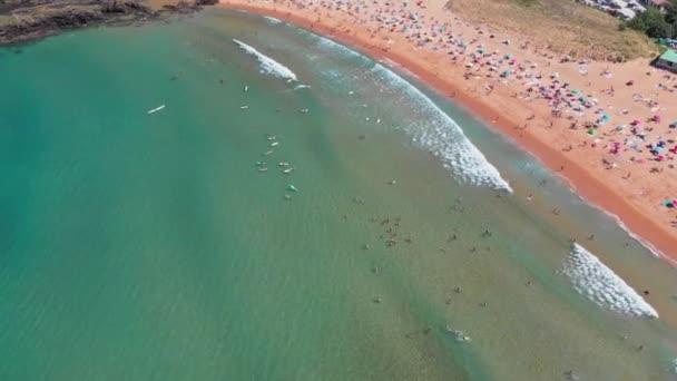 Azok az emberek, napoznak, és úszás a strandon Playa de Laga, Spanyolország. Légi felvétel — Stock videók