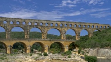Pont du Gard, antik Roma su kemeri, Güney Fransa'da, güzel mavi bulutlu gökyüzü arka plan görüntüsünü kaydırma. 4k, Uhd