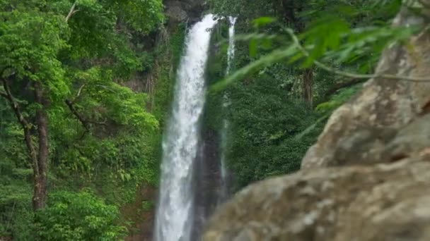 Гимбальный снимок прозрачного водопада, текущего среди пышной зеленой флоры на индонезийском острове Бали. 4K, UHD — стоковое видео