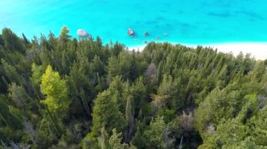 Kefalonia island, Yunanistan. Yeşil ağaçların üzerinden uçan, kum plaj ve turkuaz su