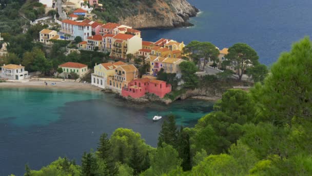 Village d'Assos en Céphalonie, Grèce. Baie turquoise en mer Méditerranée avec des maisons colorées dans le village d'Assos. 4K — Video