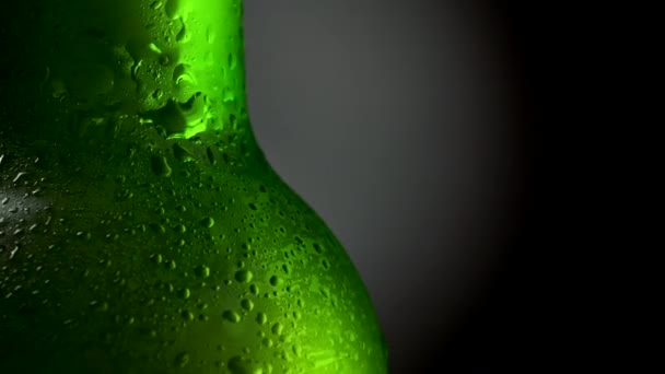 Nahaufnahme einer kalten biergrünen Flasche mit Wassertropfen. Rotation 360, schwarzer Hintergrund. uhd, 4k — Stockvideo