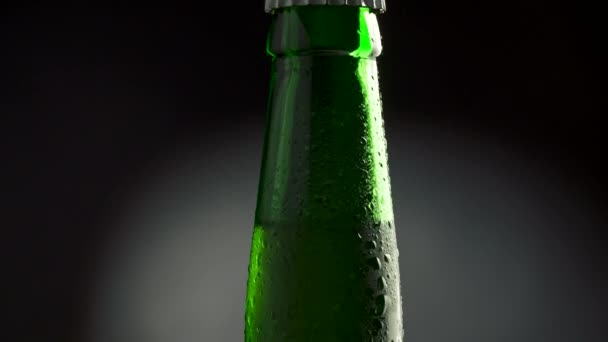 Garrafa verde clássica de cerveja gelada com condensado. Inclinar tiro com rotação. 4K UHD — Vídeo de Stock