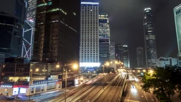 Tráfico de la ciudad de Hong Kong después del atardecer. Calle iluminada y rascacielos en Hong Kong por la noche — Vídeos de Stock