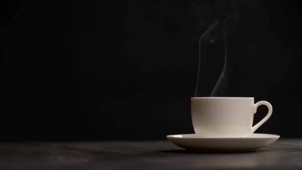 Slow motion shot of steaming cup of coffee over black background — Stock Video