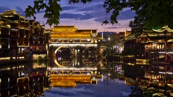 Condado de Fenghuang, China. Luces coloridas brillantes de la noche de la ciudad antigua de Fenghuang situada en la parte occidental de la provincia de Hunan. La ciudad antigua fue construida en 1704 en estilo Ming y Qing. 4K — Vídeos de Stock