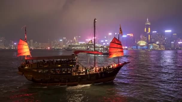 Hong Kong, Kina. Turister får en åktur runt Victoria Harbour på Aqua Luna skräp båten på kvällen. UHD — Stockvideo