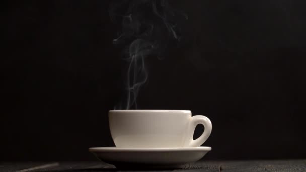 Gőzölgő forró csésze kávéval. A gőz jön a fekete háttér fehér kávéscsésze. Lassú mozgás, lövés
