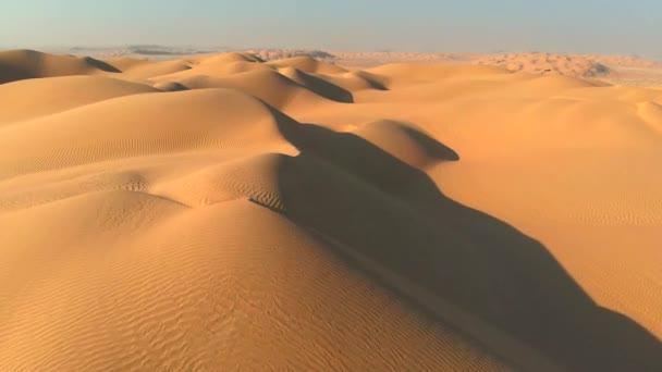 Luftaufnahme von Sanddünen in der Wüste. bei Sonnenuntergang über endlose gelbe Sanddünen fliegen — Stockvideo