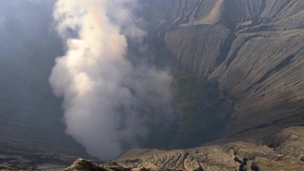 Gran nube de humo proveniente de un volcán activo. Cráter del volcán Bromo en el Parque Nacional Bromo Tengger Semeru, Java Oriental, Indonesia. Tilt shot, 4K — Vídeo de stock
