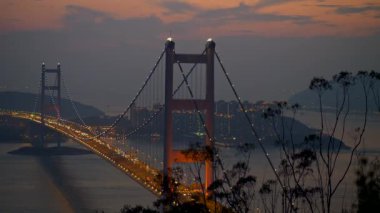 Hong Kong, Çin. Tsing Ma Bridge ve bir araba trafik doğal akşam cityscape. 1997 yılında inşa edilmiş, Tsing Ma Bridge iki Hong Kong Adaları - Tsin Yi ve Ma Wan bağlanır. Atış, 4 k kaydırma