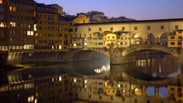 Fotografía nocturna del puente iluminado Ponte Vecchio y el río Arno en Florencia, Italia — Vídeos de Stock