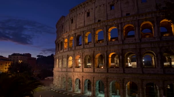 Roma, Itália. Coliseu iluminado após o pôr do sol. Panning tiro, UHD — Vídeo de Stock