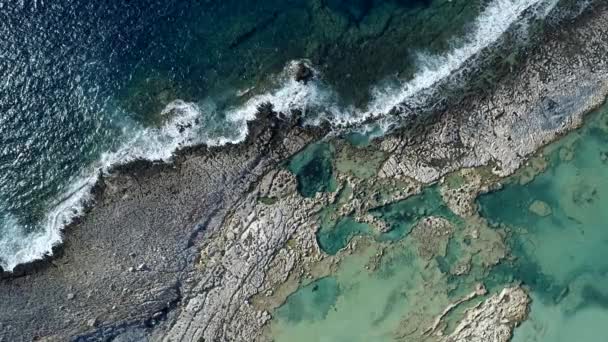 Ondas que atacam uma costa rochosa do Mar Mediterrâneo na Grécia. Cidade para baixo tiro aéreo, UHD — Vídeo de Stock