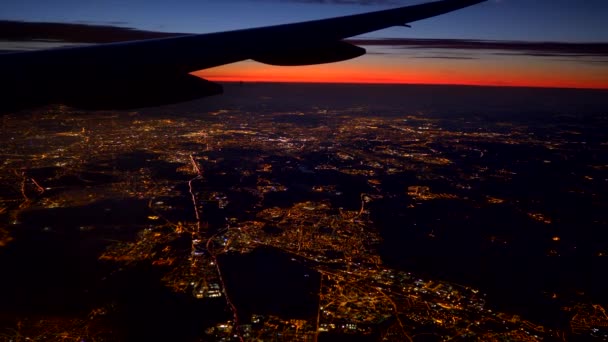 Sobrevolando las luces de la gran ciudad. Vista aérea del amanecer desde el ojo de buey plano. 4K UHD — Vídeo de stock