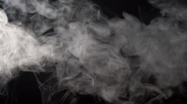 Gri bulutlar siyah bir arka plan üzerinde havada yüzer duman. Ağır çekim vurdu