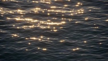 Deniz suyu ile altın kızdırma parlak yüzeyi. Güneş su günbatımı sırasında yansıtır. Ağır çekim vurdu