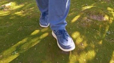 Mavi Denim Jean ayakkabı adam parkta yeşil yosun üzerinde yürüyüş
