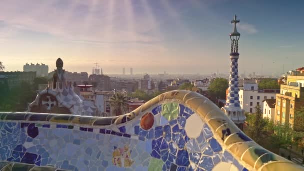 ゲール公園からバルセロナ市内の景色を眺めながらのクレーンショット。パークゲルのカラフルなモザイクの建物の日の出の眺め。ウード、4k — ストック動画