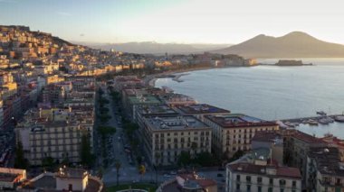 Sabah Napoli, İtalya muhteşem panorama. Şehrin sokaklarına giden arabalar, tekneler koya demirledi. Güneş gün doğumu sırasında parlıyor. Vezüv yanardağı arka planda görülür. 4k