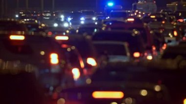 Büyük bir şehirde akşam saatlerinde trafik sıkışıklığı içinde yavaş yavaş giden arabalar. Bulanık araba ışıkları güzel soyut görüş. 4k